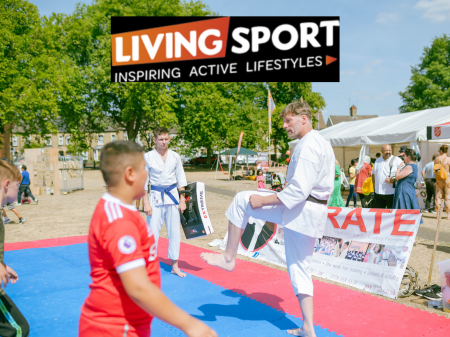 Photo of 2 young people with an adult practicing Karate on the field at the Millfield Festival. Their place funded by Living Sport. 