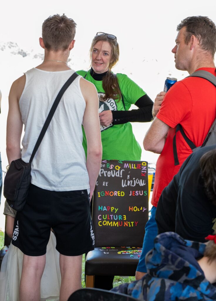 In the Creative dome at the Peterborough Celebrated Festival.... Artist Fae Kilburn is talking to 2 men as they are stood by the access chairs with colourful letters and words stuck to them.