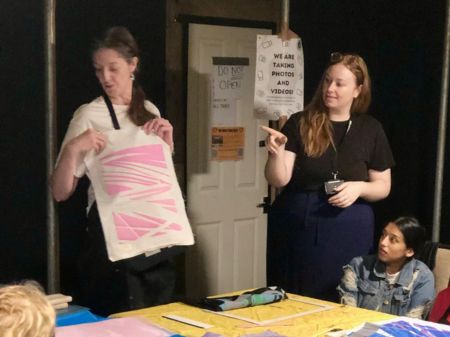 Fae (left) showing an example of a print on fabric as Poppy (right) BSL interprets.