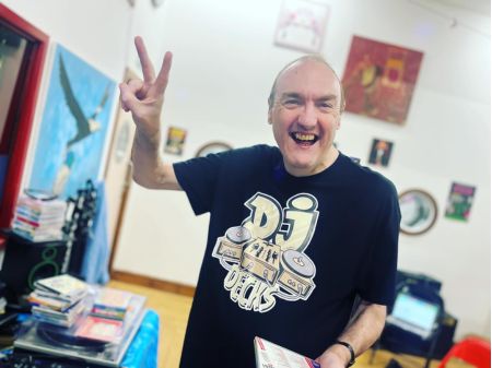A DDN person smiling and posing with peace signs to the camera