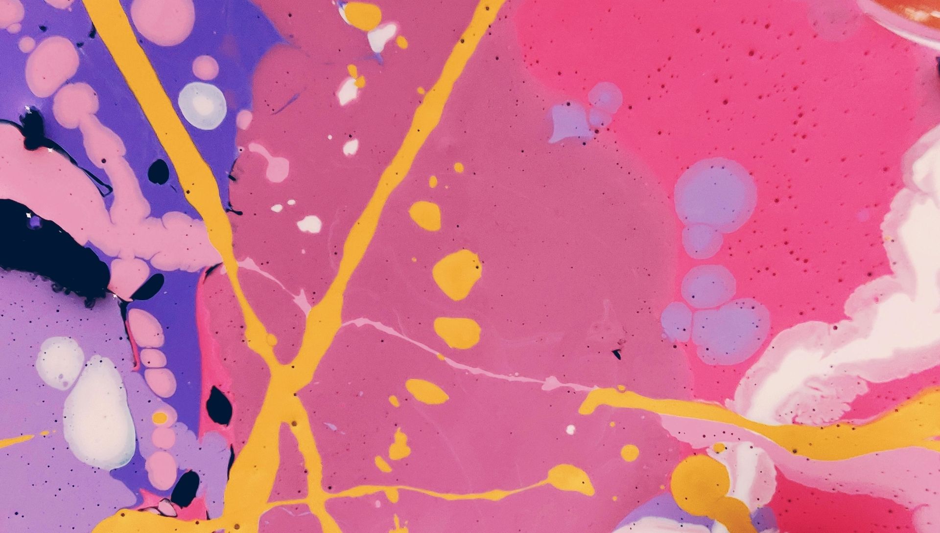 Colourful paint splatter design. Pink, purple and yellow paints in drips and brush marks across the image.